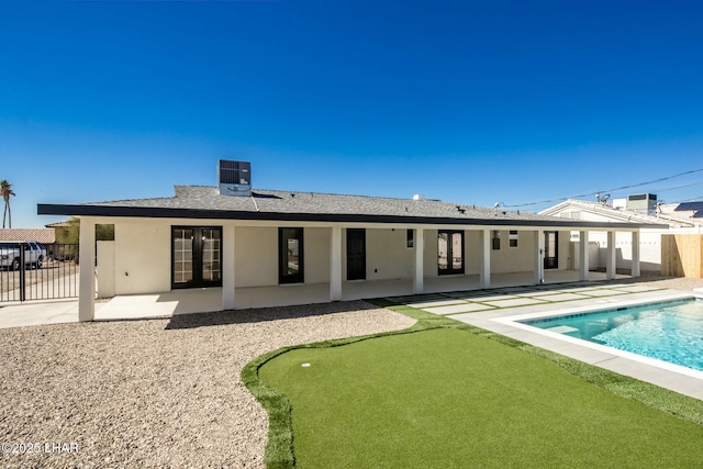 rear view of house featuring french doors, a patio area, fence, and stucco siding