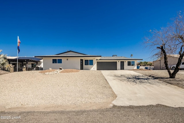 view of front facade with driveway, an attached garage, and stucco siding