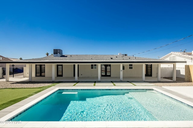 rear view of house featuring a patio area, fence, an outdoor pool, and cooling unit