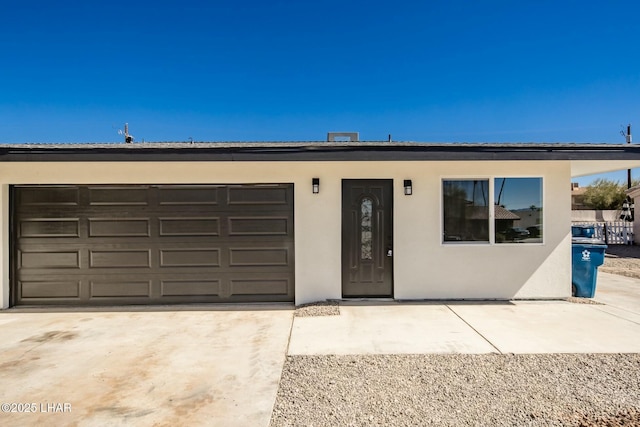 view of front of house featuring a garage, driveway, and stucco siding