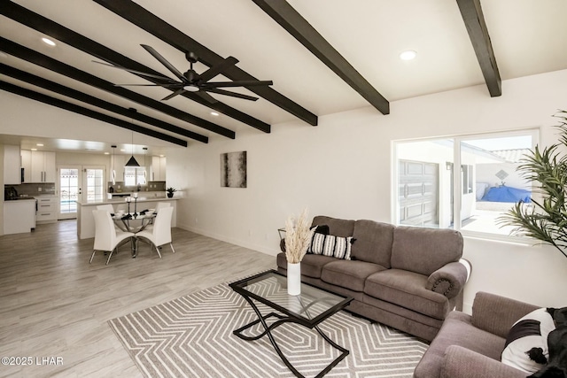 living area with french doors, light wood finished floors, lofted ceiling with beams, ceiling fan, and baseboards