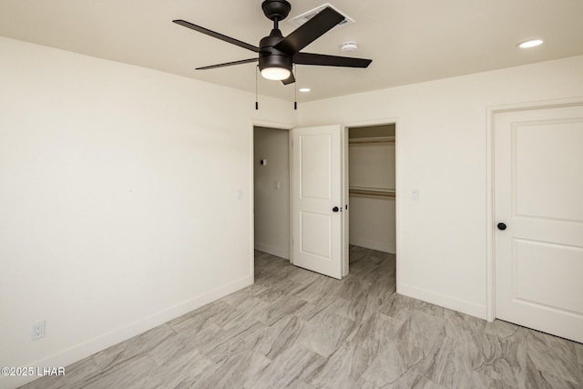 unfurnished bedroom featuring a walk in closet, recessed lighting, a closet, ceiling fan, and baseboards