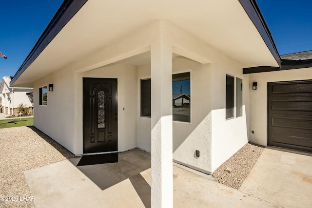 doorway to property featuring stucco siding