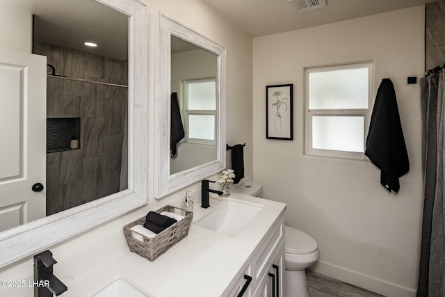 full bathroom featuring vanity, walk in shower, toilet, and baseboards