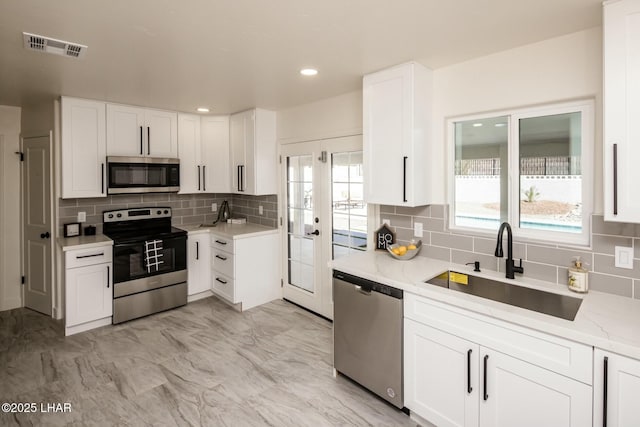 kitchen featuring appliances with stainless steel finishes, a healthy amount of sunlight, visible vents, and a sink