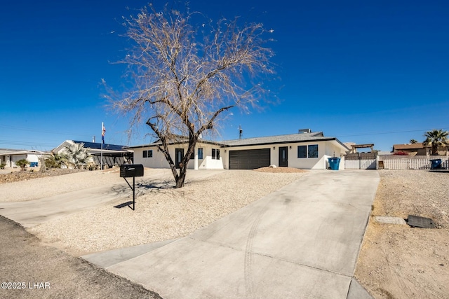 ranch-style home with driveway, an attached garage, fence, and a gate