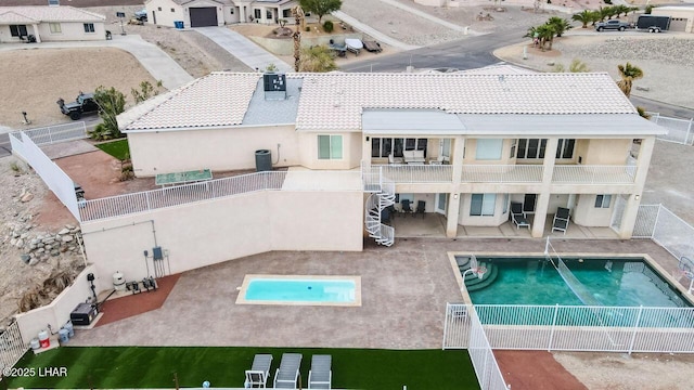 rear view of property with a fenced backyard, stucco siding, stairs, and a patio