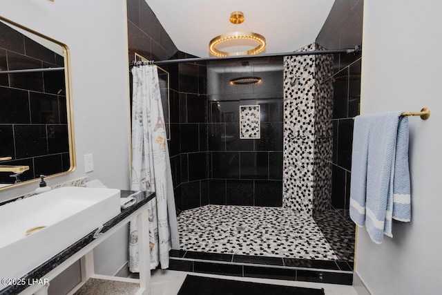 bathroom featuring a stall shower and a sink