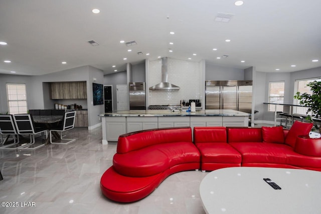 living room featuring recessed lighting, plenty of natural light, visible vents, and lofted ceiling