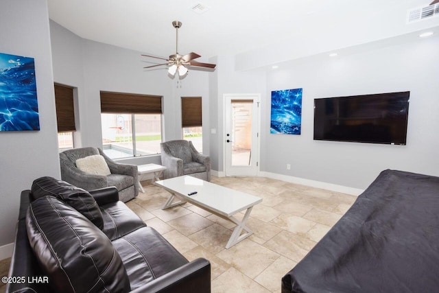 living area featuring visible vents, baseboards, and ceiling fan