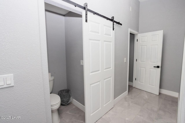 bathroom featuring toilet and baseboards