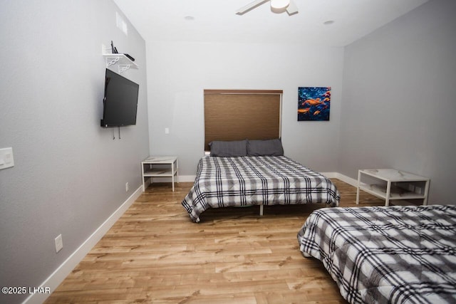 bedroom with light wood finished floors and baseboards