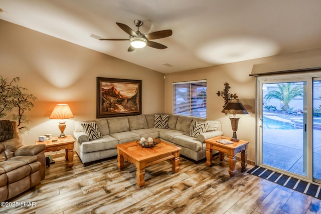 living room featuring lofted ceiling, hardwood / wood-style flooring, and ceiling fan