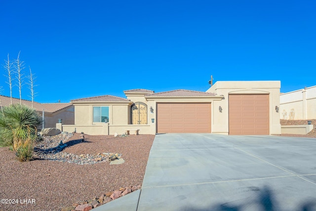 2555 Avalon Ln, Lake Havasu City, AZ 86404 - view of front facade with a garage, driveway, stucco siding, and a tiled roof