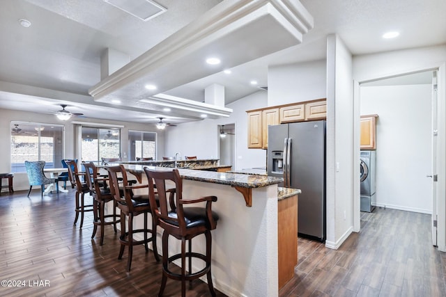 2555 Avalon Ln, Lake Havasu City, AZ 86404 - kitchen featuring stainless steel refrigerator with ice dispenser, ceiling fan, a kitchen bar, dark wood-style floors, and washer / dryer