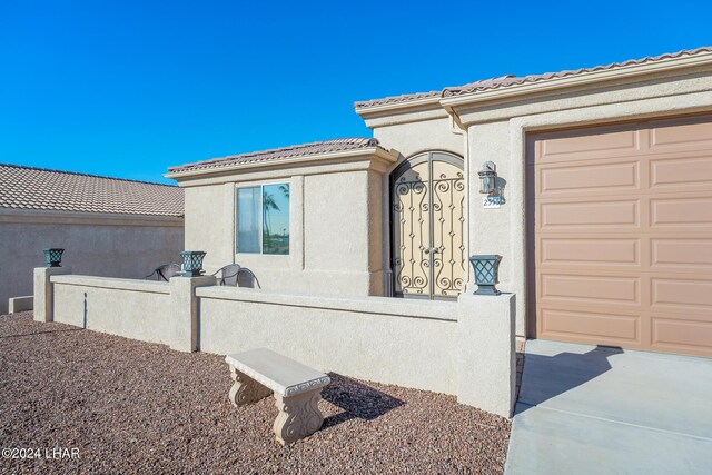 2555 Avalon Ln, Lake Havasu City, AZ 86404 - entrance to property with stucco siding, fence, a garage, and a tile roof