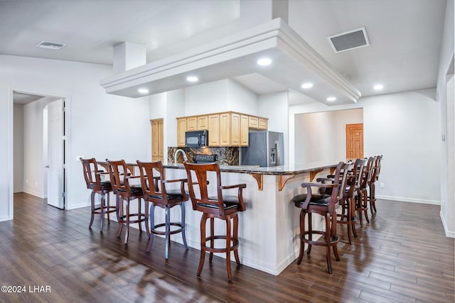 2555 Avalon Ln, Lake Havasu City, AZ 86404 - kitchen featuring black microwave, stainless steel fridge, light brown cabinetry, a breakfast bar area, and recessed lighting