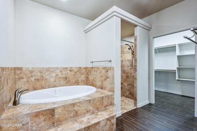 2555 Avalon Ln, Lake Havasu City, AZ 86404 - bathroom with a spacious closet, tiled shower, a garden tub, wood finished floors, and baseboards