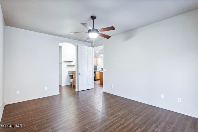 2555 Avalon Ln, Lake Havasu City, AZ 86404 - unfurnished bedroom with arched walkways, dark wood-style floors, baseboards, and a ceiling fan