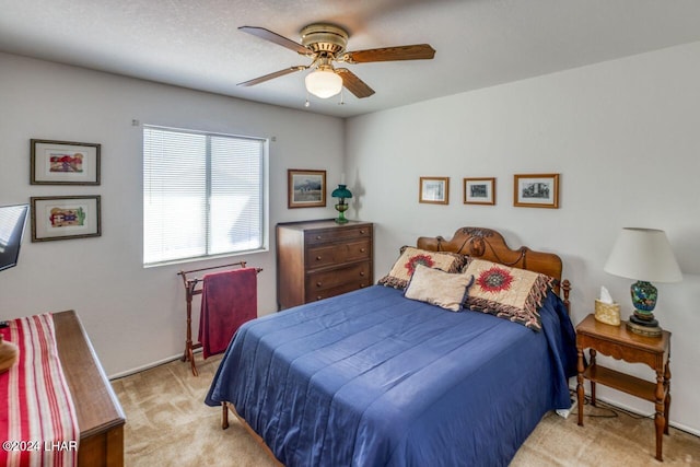 bedroom featuring light colored carpet and ceiling fan