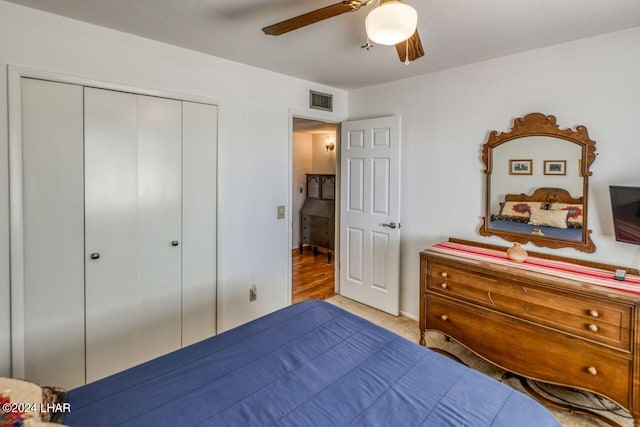 carpeted bedroom featuring ceiling fan and a closet