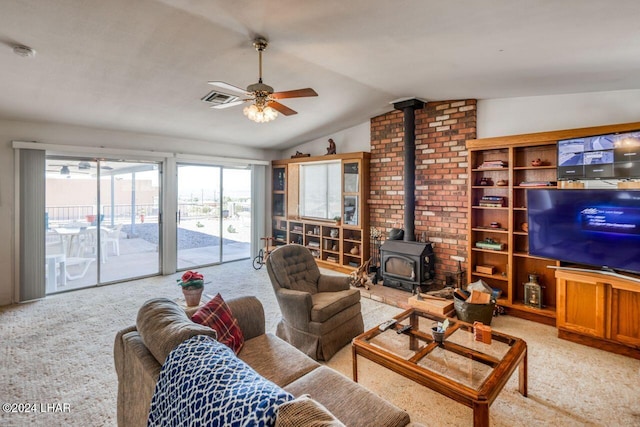 carpeted living room with lofted ceiling, ceiling fan, and a wood stove