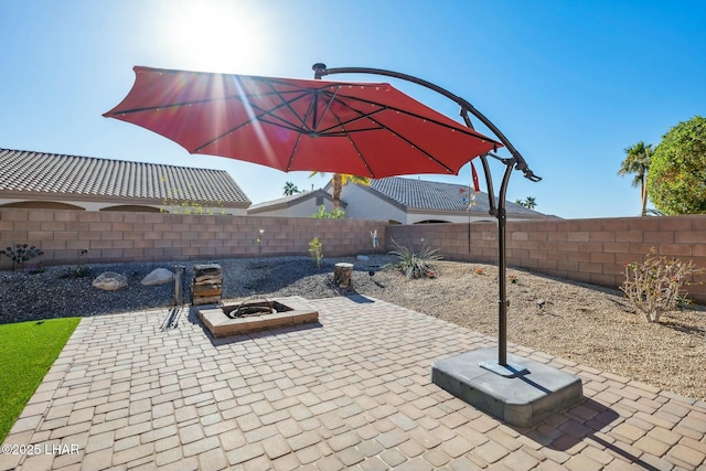 view of patio / terrace with a fenced backyard and a fire pit