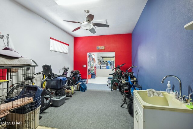 interior space with a ceiling fan, a sink, and carpet