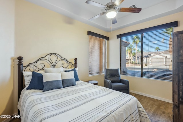 bedroom with visible vents, baseboards, a ceiling fan, and wood finished floors
