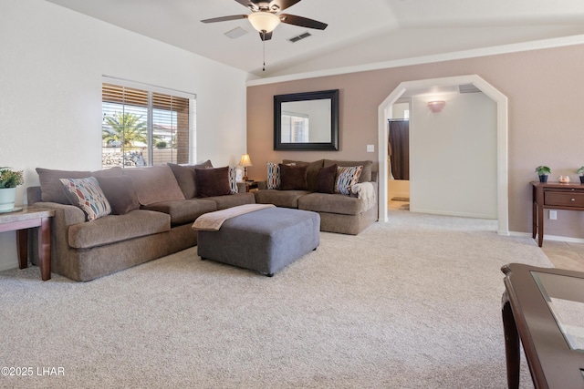 living room featuring lofted ceiling, ceiling fan, visible vents, and light colored carpet