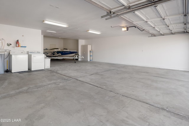 garage with a garage door opener and independent washer and dryer