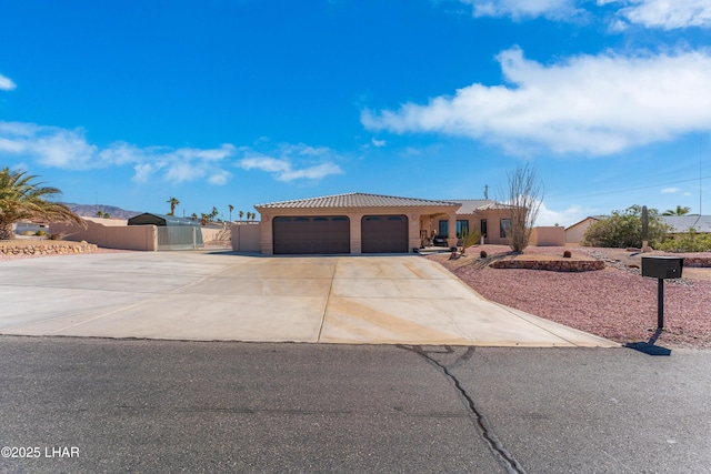 view of front facade with a garage, driveway, a tile roof, and stucco siding