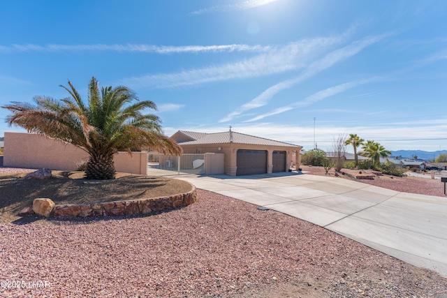 view of front facade with an attached garage, a tiled roof, concrete driveway, and stucco siding