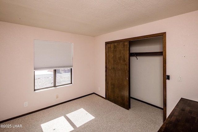 unfurnished bedroom with a closet, light carpet, and a textured ceiling