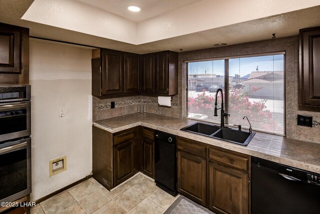 kitchen featuring double oven, dishwasher, sink, backsplash, and dark brown cabinetry