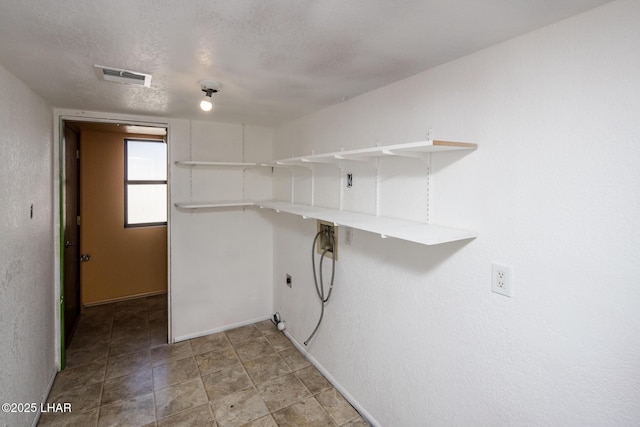 laundry area with hookup for a washing machine, hookup for an electric dryer, and a textured ceiling