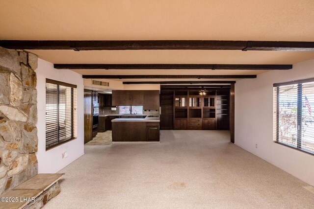 unfurnished living room featuring beamed ceiling