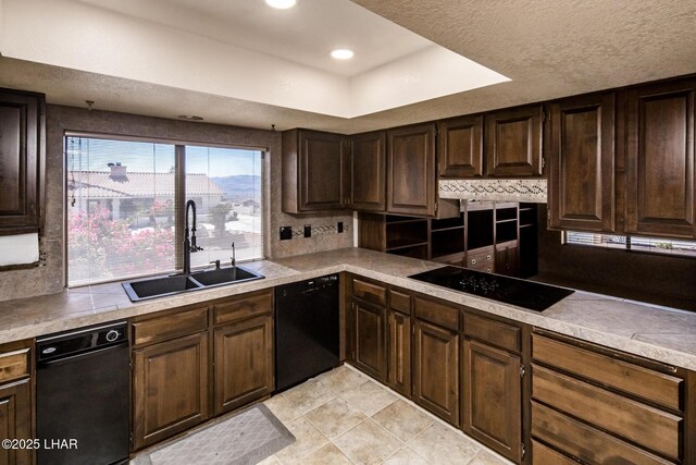 kitchen featuring sink, dark brown cabinetry, black appliances, a textured ceiling, and decorative backsplash