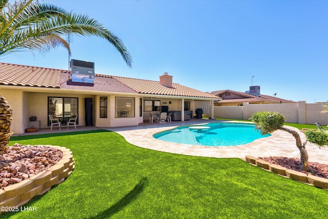 view of swimming pool with cooling unit, a lawn, and a patio area