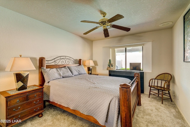 bedroom featuring ceiling fan, light carpet, and a textured ceiling