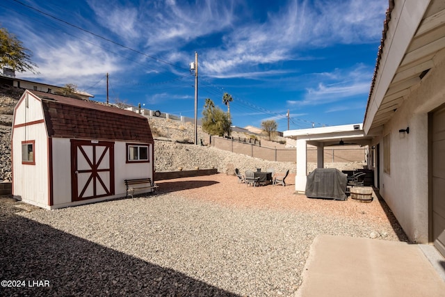 view of yard with a storage shed and a patio area