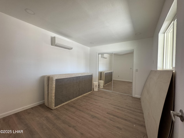31567 94th St, Parker, AZ 85344 - unfurnished room featuring a wall mounted AC, wood finished floors, and baseboards
