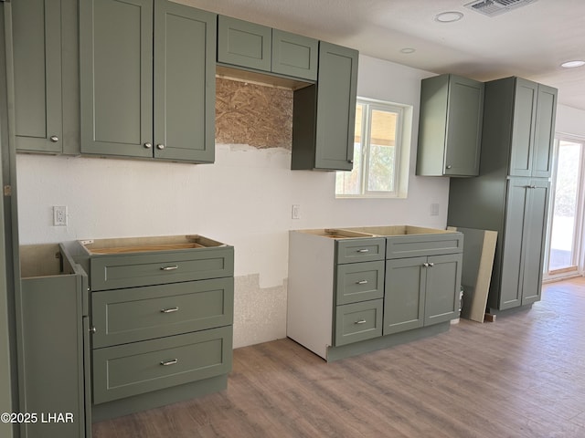 31567 94th St, Parker, AZ 85344 - kitchen featuring wood finished floors, green cabinets, and plenty of natural light