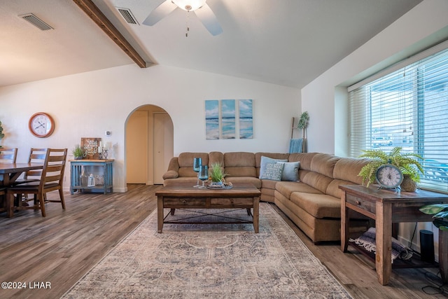 living room featuring ceiling fan, wood-type flooring, and vaulted ceiling with beams