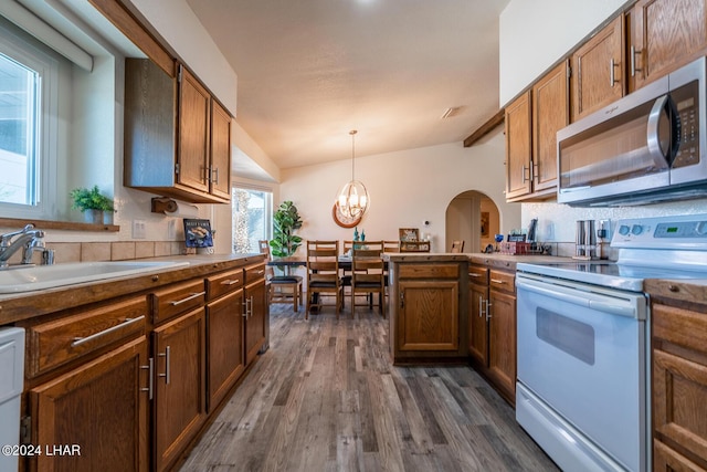 kitchen featuring sink, dark wood-type flooring, an inviting chandelier, white electric range oven, and decorative light fixtures