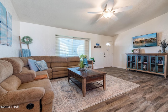 living room with vaulted ceiling, wood-type flooring, a textured ceiling, and ceiling fan