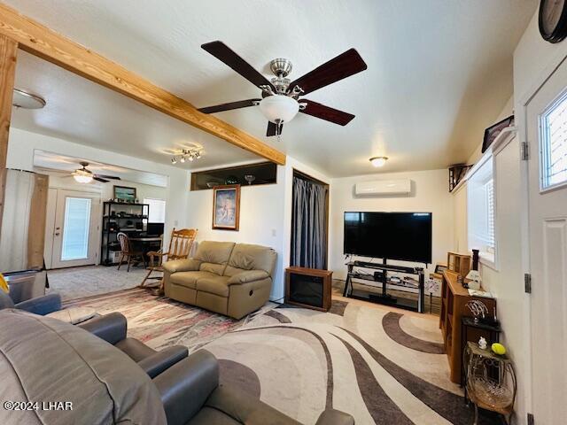 living room with beamed ceiling, an AC wall unit, light carpet, and ceiling fan