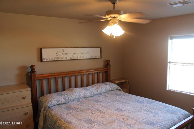 bedroom with visible vents, ceiling fan, and multiple windows