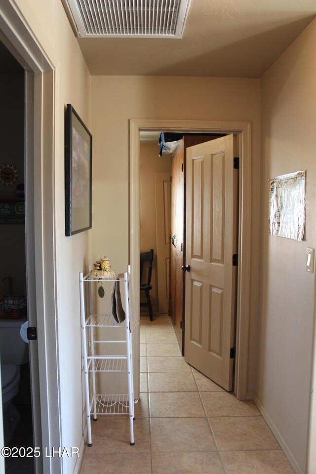 corridor featuring visible vents and light tile patterned flooring