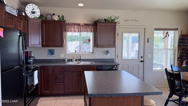 kitchen with a kitchen island, a sink, a wealth of natural light, black appliances, and dark countertops